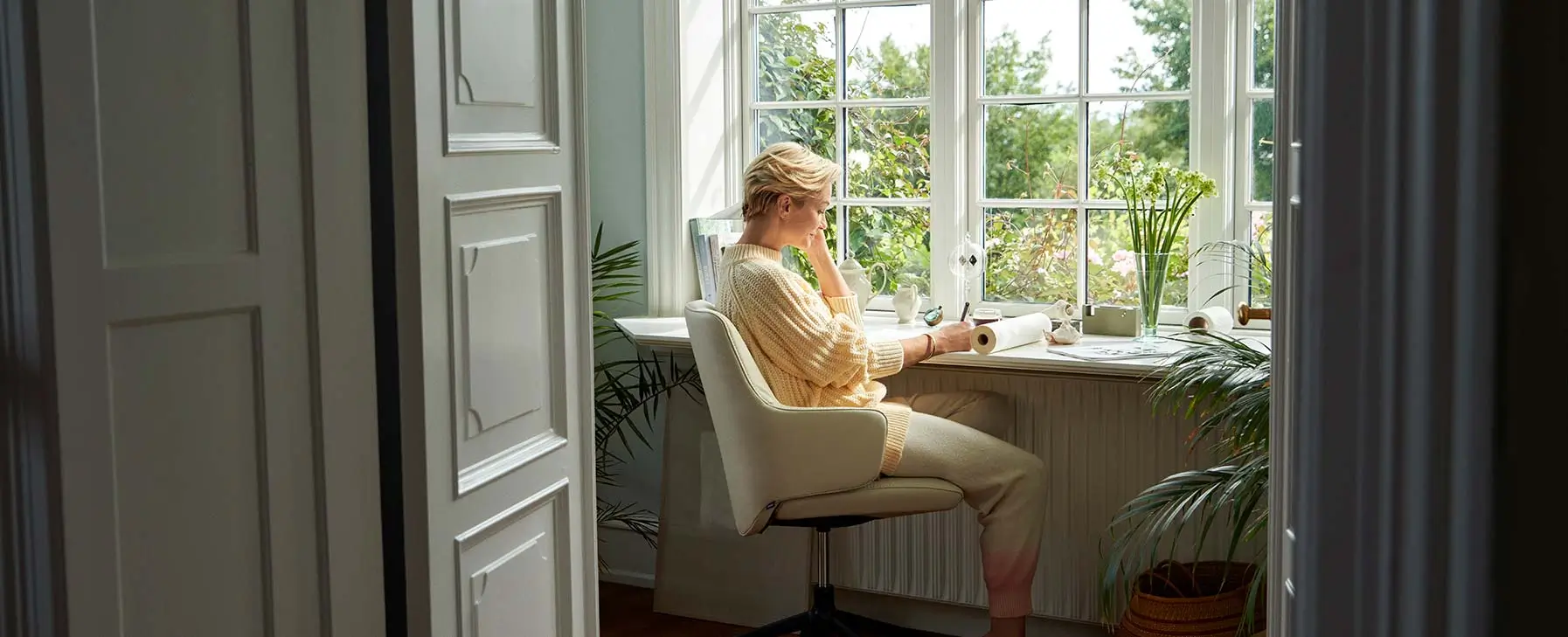 Eine Frau sitz auf dem Stressless Laurel am Schreibtisch